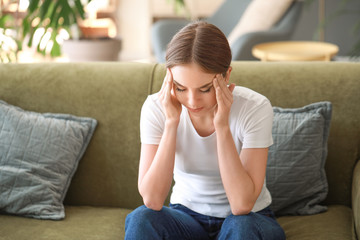 Fototapeta premium Young woman suffering from headache at home