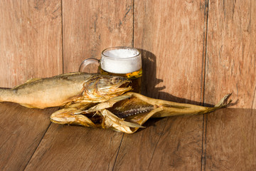 Oktoberfest holiday concept. Smoked fish and a glass of beer. Cold smoked pike perch on a dark rustic background.