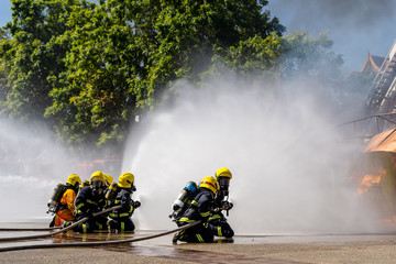 Firefighters are fighting fire with a fire brigade, Firefighters fighting fire during training with high pressure water to fire