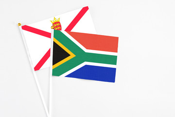 Fototapeta premium South Africa and Jersey stick flags on white background. High quality fabric, miniature national flag. Peaceful global concept.White floor for copy space.