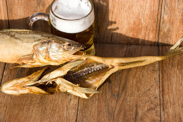 Oktoberfest holiday concept. Smoked fish and a glass of beer. Cold smoked pike perch on a dark rustic background.