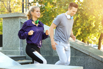 Sporty young couple running in park