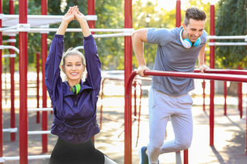 Fototapeta premium Sporty young couple training on athletic field outdoors