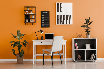 Fototapeta premium Stylish workplace with laptop near color wall