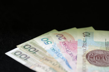 Polish zloty banknotes on a dark surface close-up. Money background green color toned