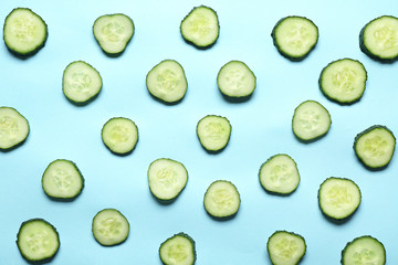 Pieces of fresh cucumbers on color background