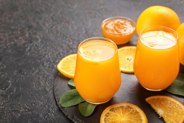 Glasses of fresh orange juice on dark background