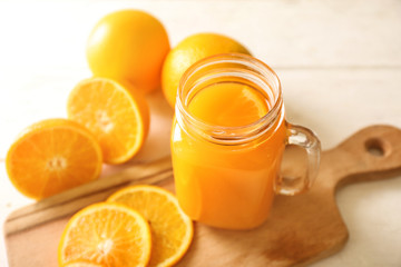 Fototapeta na wymiar Mason jar of fresh orange juice on table