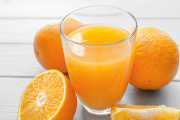 Glass of fresh orange juice on wooden table