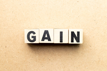 Obraz premium Letter block in word gain on wood background