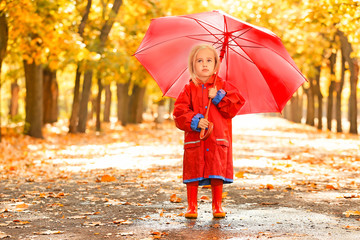 Obraz premium Cute little girl with umbrella in autumn park