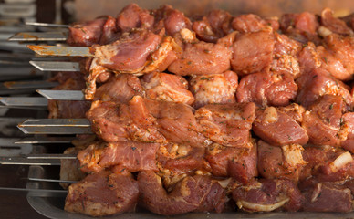 Raw meat on skewers. Meat slices prepare on fire.