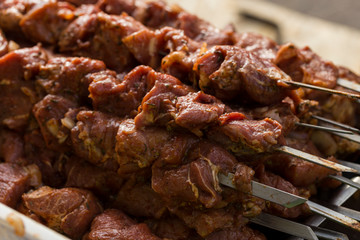 Raw meat on skewers. Meat slices prepare on fire.