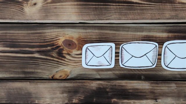 Paper drawing sketches with mail-themed letters on wooden