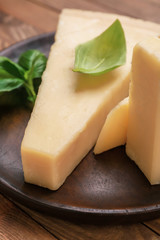 Plate with tasty Parmesan cheese on wooden background, closeup