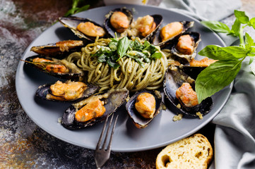 Close-up Delicious seafood pasta. Fresh mussels and pesto pasta. Mediterranean Kitchen.