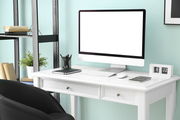 Fototapeta na wymiar Comfortable workplace with modern computer near color wall