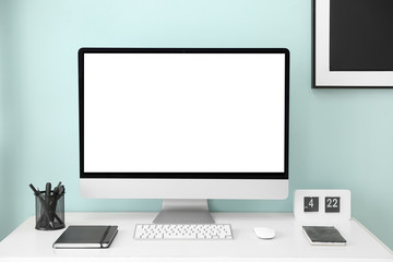 Fototapeta premium Comfortable workplace with modern computer near color wall
