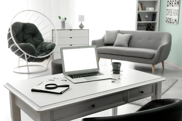 Comfortable workplace with modern laptop in room