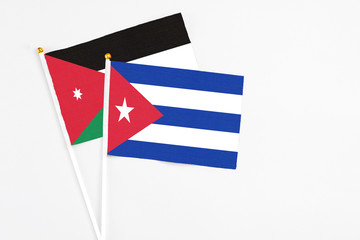 Cuba and Jordan stick flags on white background. High quality fabric, miniature national flag. Peaceful global concept.White floor for copy space.