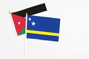 Curacao and Jordan stick flags on white background. High quality fabric, miniature national flag. Peaceful global concept.White floor for copy space.
