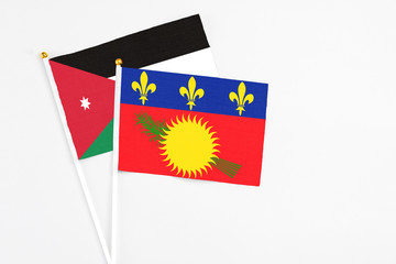 Guadeloupe and Jordan stick flags on white background. High quality fabric, miniature national flag. Peaceful global concept.White floor for copy space.