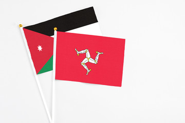 Isle Of Man and Jordan stick flags on white background. High quality fabric, miniature national flag. Peaceful global concept.White floor for copy space.