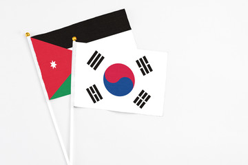 South Korea and Jordan stick flags on white background. High quality fabric, miniature national flag. Peaceful global concept.White floor for copy space.