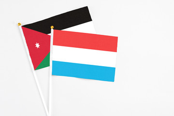 Luxembourg and Jordan stick flags on white background. High quality fabric, miniature national flag. Peaceful global concept.White floor for copy space.