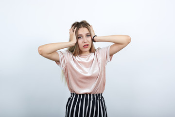 Attractive young pretty woman wearing nice shirt and funny with nice haircut,looking frustrated and takes hands on head, over isolated white background