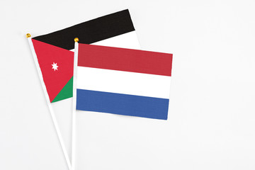 Netherlands and Jordan stick flags on white background. High quality fabric, miniature national flag. Peaceful global concept.White floor for copy space.