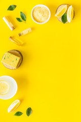 Lemon cosmetics. Cleansing tonic and handmade soap on yellow background top view frame copy space