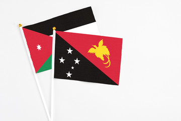 Papua New Guinea and Jordan stick flags on white background. High quality fabric, miniature national flag. Peaceful global concept.White floor for copy space.