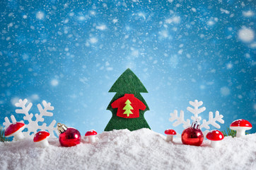Christmas tree and Christmas decorations on snow. Blue bokeh background