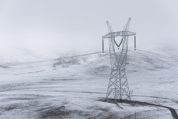 electricity pylon on mountain which covered with snow