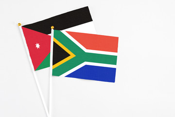 South Africa and Jordan stick flags on white background. High quality fabric, miniature national flag. Peaceful global concept.White floor for copy space.