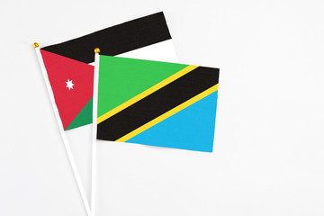 Tanzania and Jordan stick flags on white background. High quality fabric, miniature national flag. Peaceful global concept.White floor for copy space.