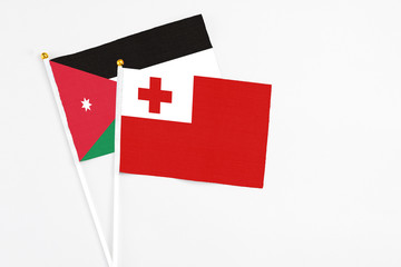 Tonga and Jordan stick flags on white background. High quality fabric, miniature national flag. Peaceful global concept.White floor for copy space.