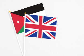 United Kingdom and Jordan stick flags on white background. High quality fabric, miniature national flag. Peaceful global concept.White floor for copy space.