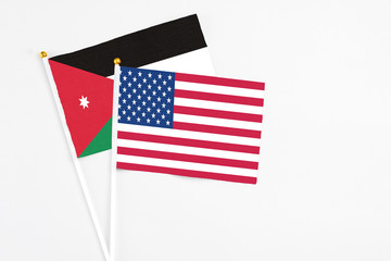 United States and Jordan stick flags on white background. High quality fabric, miniature national flag. Peaceful global concept.White floor for copy space.