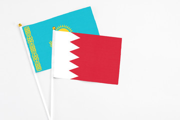 Bahrain and Kazakhstan stick flags on white background. High quality fabric, miniature national flag. Peaceful global concept.White floor for copy space.