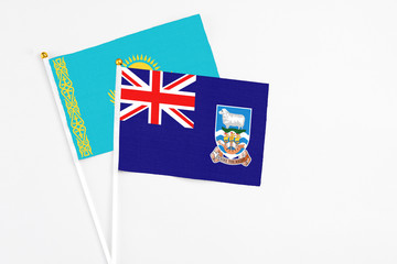 Fototapeta premium Falkland Islands and Kazakhstan stick flags on white background. High quality fabric, miniature national flag. Peaceful global concept.White floor for copy space.
