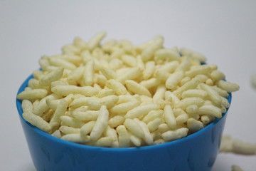 close up picture of Puffed rice on the blue bowl with white background
