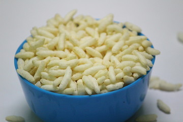 close up picture of Puffed rice on the blue bowl with white background