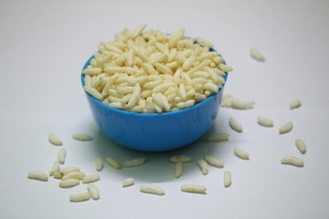 close up picture of Puffed rice on the blue bowl with white background