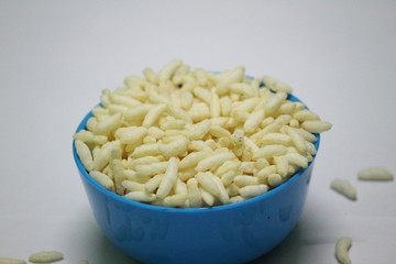 close up picture of Puffed rice on the blue bowl with white background