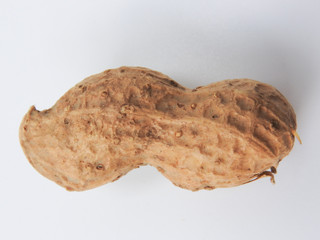 Top view of an raw unshelled peanuts also called groundnut isolated on white background. With edible seeds and high oil content. Oil crop. Food and Taiwan agriculture concept.