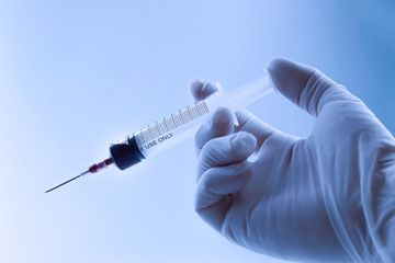 syringe with a vaccine in his hand