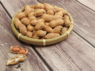 High angle view of a pile of raw peanuts also called groundnut isolated on wooden background. With edible seeds and high oil content. Oil crop. Food and Taiwan agriculture concept. With copy space.