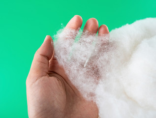 Holding a long pile of cotton on a green background